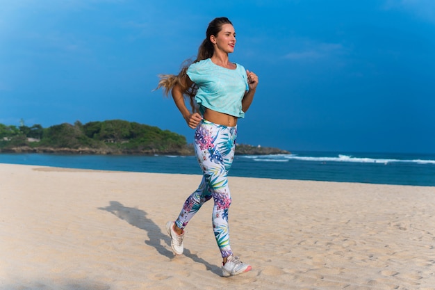 Sportieve vrouw die op het strand loopt