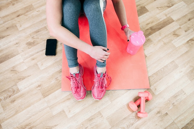 Sportieve vrouw die pauze neemt voor drinkwater na training