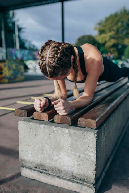 Sportieve vrouw die plank oefent in het park