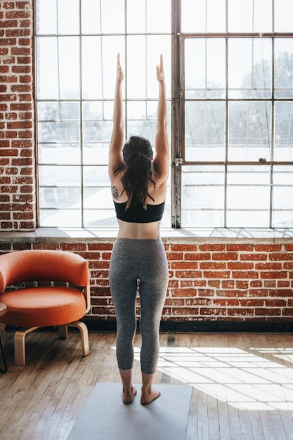 Sportieve vrouw die yoga op de kamer doet