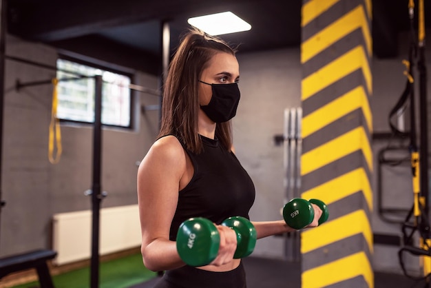 Sportieve vrouw doet oefeningen met halters in de sportschool