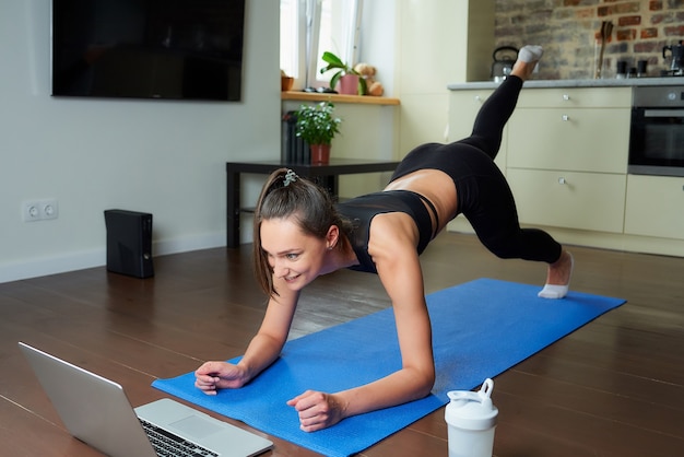 Sportieve vrouw in een trainingsoutfit thuis