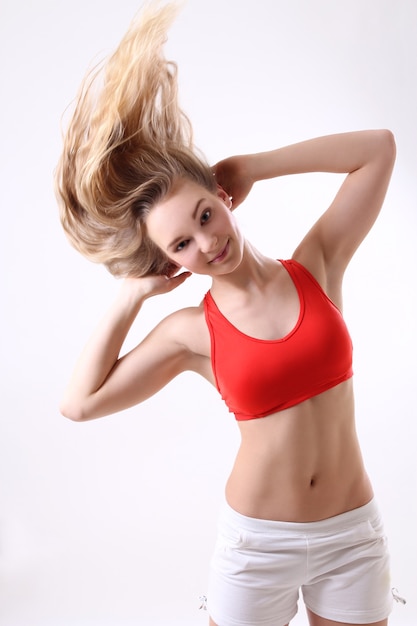 Sportieve vrouw met lang waaiend haar op witte achtergrond