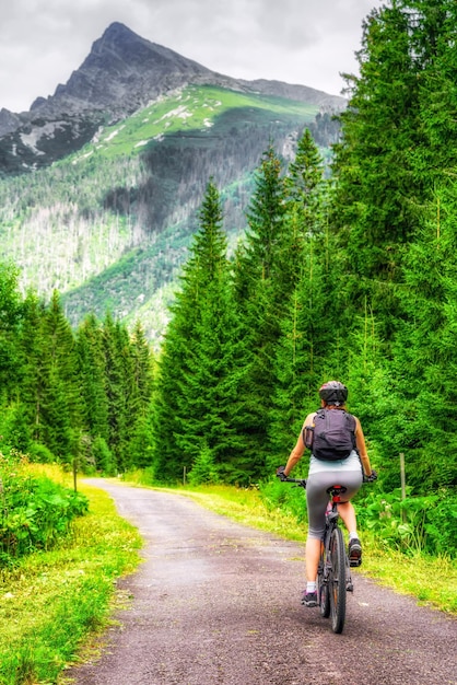 Sportieve vrouw op MTB-fiets op de weg in de Koprova-vallei in het Hoge Tatra-gebergte Slowakije Zomer