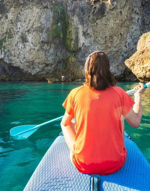 Sportieve vrouw op paddle surfplank