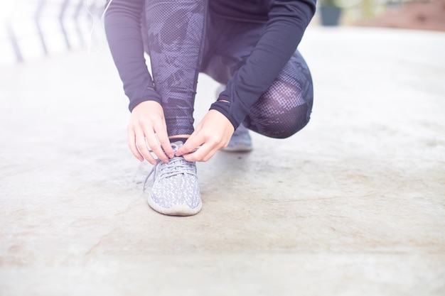 Sportieve vrouwen bindende schoenveter op loopschoenen vóór praktijk