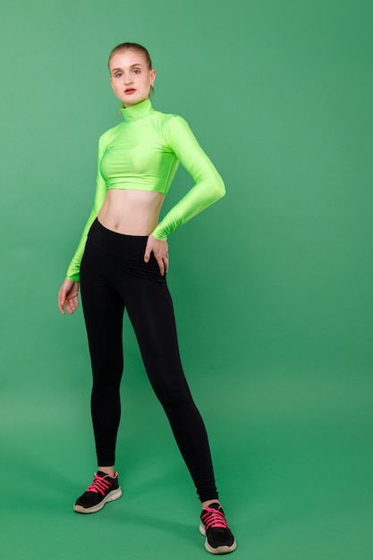 Sporting slender girl in leggings on a green space