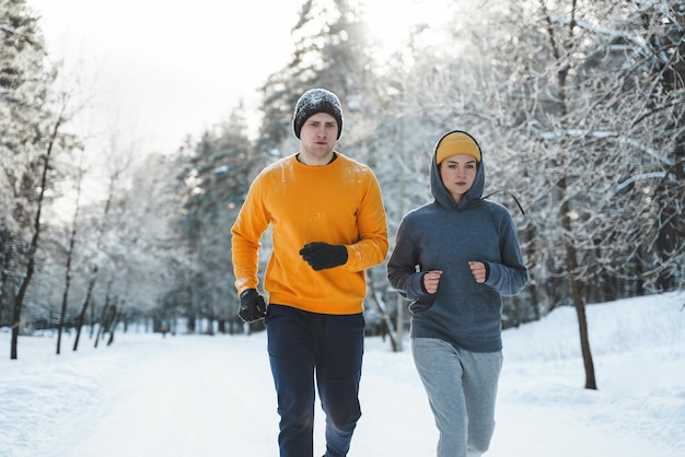 Coppia sportiva durante l'inverno a fare jogging nel parco cittadino innevato