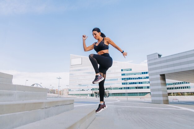 Sportive girl with fit body training outside 