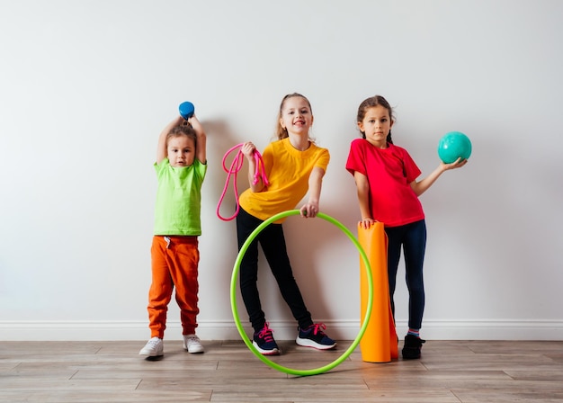 Sportive kids in colorful tshirts posing with sport equipment