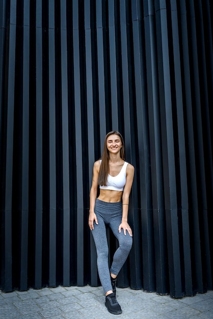 Sportive and very slim woman posing outdoors on abstract background