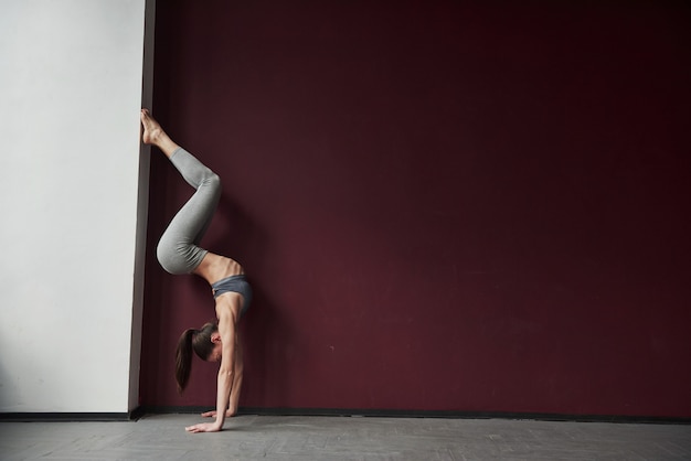 Foto donna allegra in azione. la ragazza con un buon tipo di corpo fitness ha esercizi nella stanza spaziosa