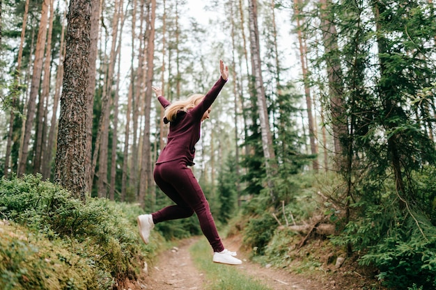 森でジャンプ陽気な女性。