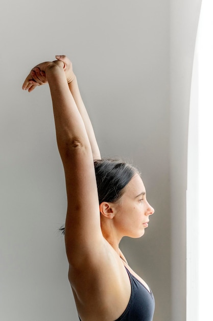 Photo sportive woman stretching hands up