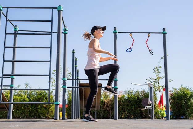 Спортивная женщина, тренирующаяся на спортивной площадке в солнечный летний день