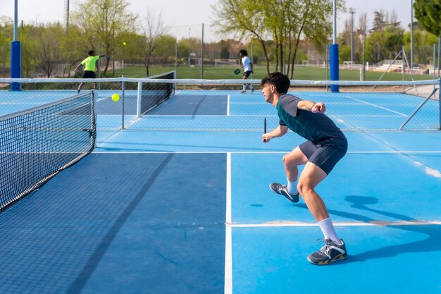 Foto giovane sportivo che gioca a pickleball sotto il sole