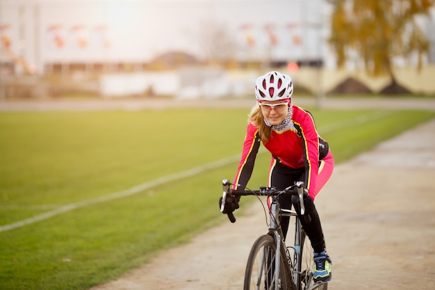 Sportive young woman cycling in park training