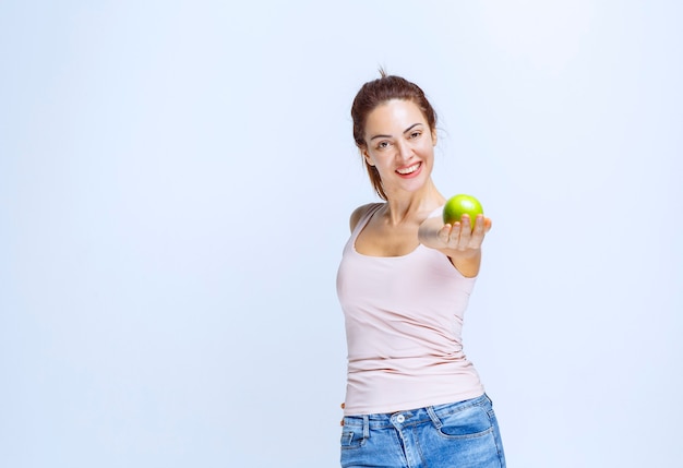 Sportive Young woman offering green apples