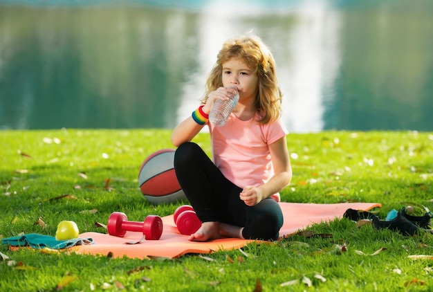 Sportkinderen jongenskinderen ontspannen op sportmat na sportoefeningen buiten in het park