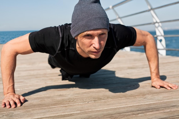 Foto sportman doet pushups op pier