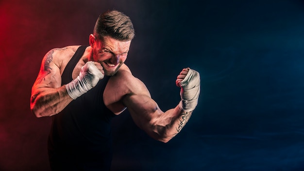 Sportman muay thai bokser vechten op zwarte muur met rook. Sport concept.