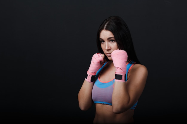 Sportman muay thai vrouw bokser portret in opleiding studio op zwarte achtergrond.