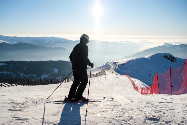 Sportman skiër op besneeuwde helling achtergrond van blauwe lucht en prachtig berglandschap