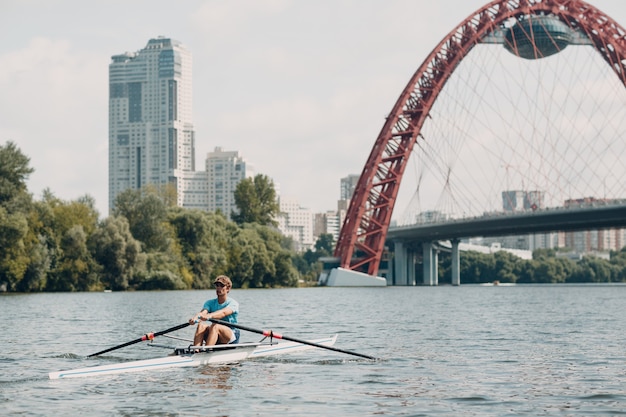 Sportman skiff man roeier roeien op boot