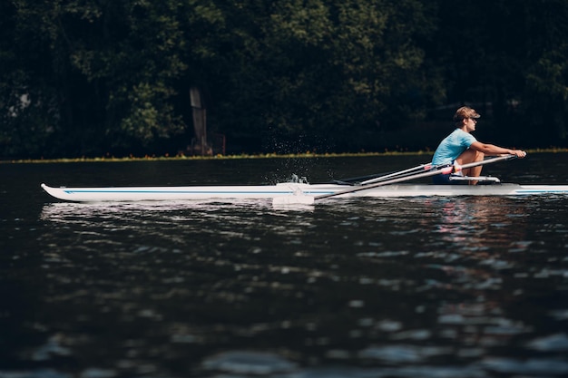 Sportman skiff man roeier roeien op boot