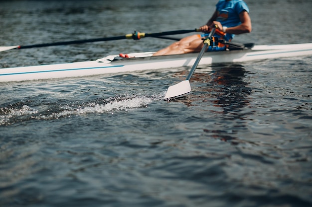 Sportman skiff man roeier roeien op boot