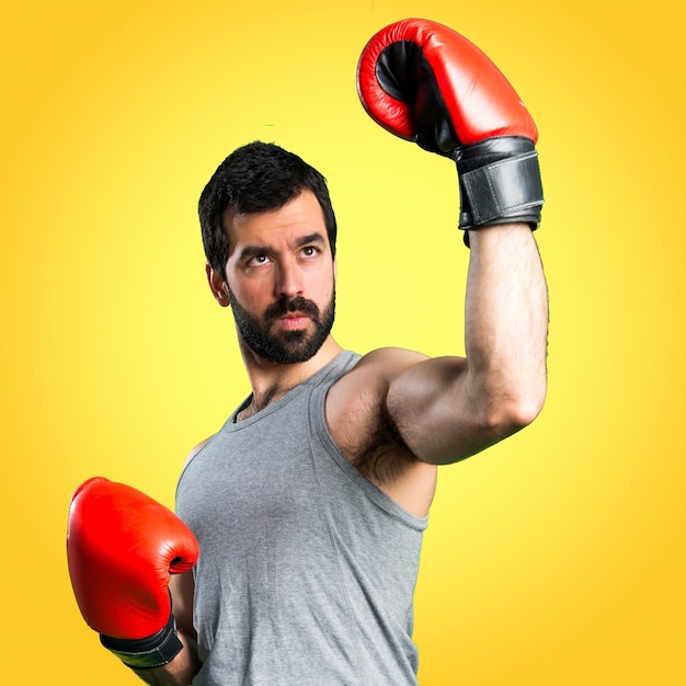 Sportman with boxing gloves on colorful background