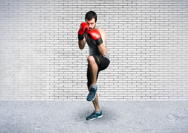 Sportman with boxing gloves on colorful background