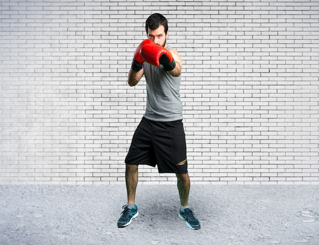 Sportman with boxing gloves on colorful background