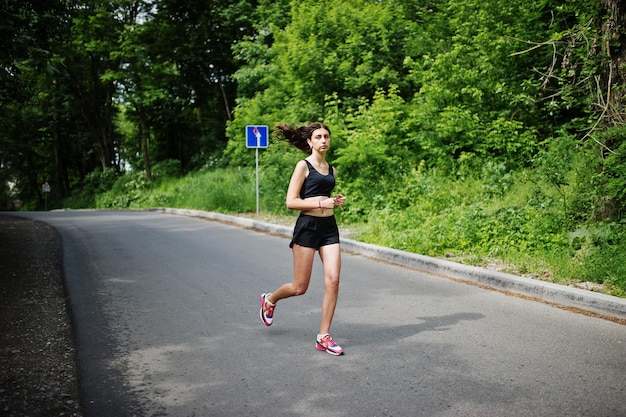 Sportmeisje bij sportkleding die in een groen park loopt en in de natuur traint Een gezonde levensstijl