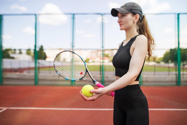 Sportmeisje met racket en tennisbal Een mooi jong meisje oefent De tennisspeler bereidt zich voor om te dienen