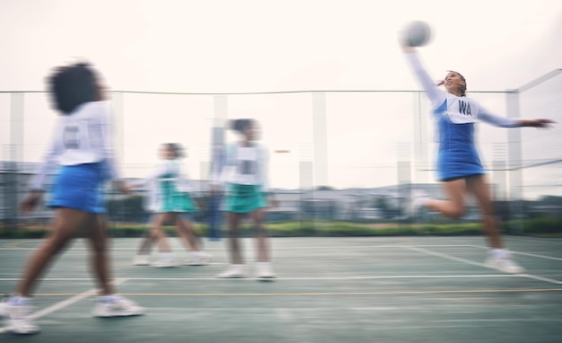 Sportnetbal en fitnesssprong door vrouwen op buitenbaan voor training, training en oefening Train studenten en meisjesteam met bal voor wedstrijdsnelheid en prestaties terwijl ze actief zijn op het veld