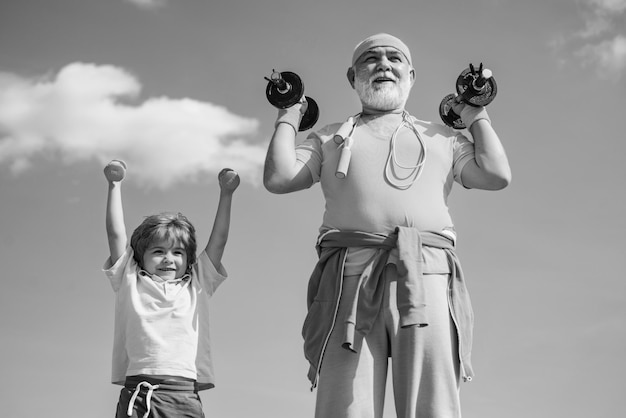 Sportoefening voor kinderen die dumbbells optillen portret van senior man en schattig kind die dumbbells optillen gr