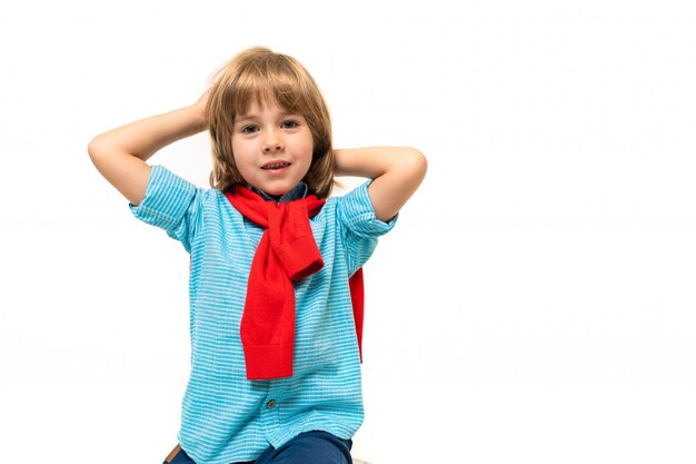 Sports  boy in t-shirt with hoody around his neck gesticulates isolated on blue 