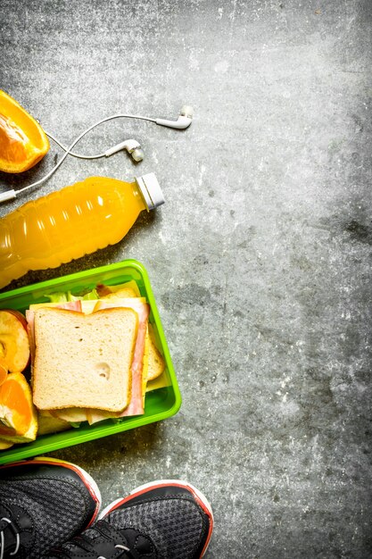 Sports Breakfast. Sandwiches, orange juice and fruit. On the stone table.