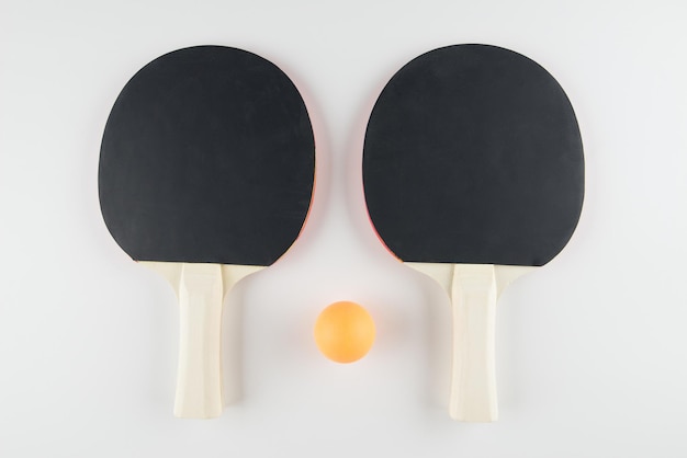 Foto composizione sportiva ping pong primo piano racchette e pallina per giocare su sfondo bianco