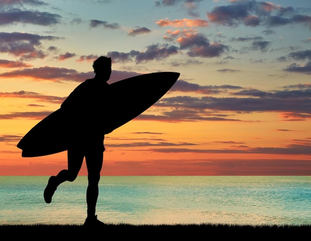 スポーツの概念。夕日の海の背景にビーチでサーファーのシルエット