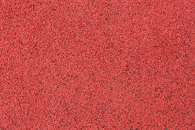 Sports court or playground background. Artificial rubber coating for playgrounds and sports places in red color