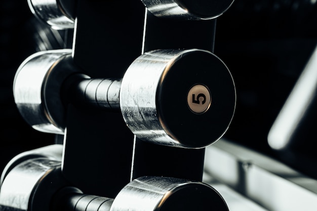 Sports equipment in gym. Dumbbells of different weight close up