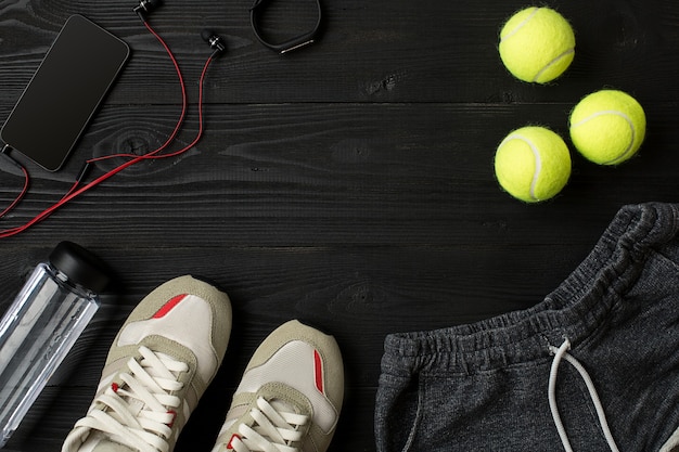 Sports equipment and wear on dark wooden background top view