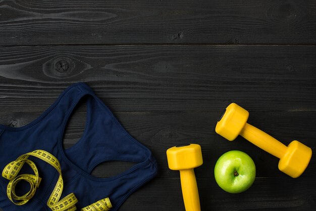 Sports equipment and wear on dark wooden background top view