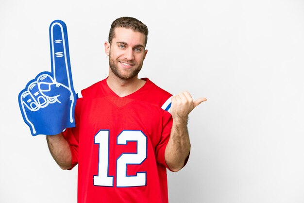 Sports fan man over isolated white background pointing to the side to present a product