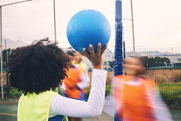 トレーニングトレーニングと練習のための屋外コートでの女性によるスポーツフィットネスとネットボールの試合 運動学生とボールを持った女子チームがフィールドで活動しながら競争のスピードとパフォーマンスを競う