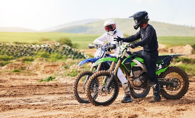 Sports friends and men with motorcycle in countryside for fun hobby and stunt training practice or freedom Off road on dirt motorbike and biker people in nature for adrenaline challenge or race