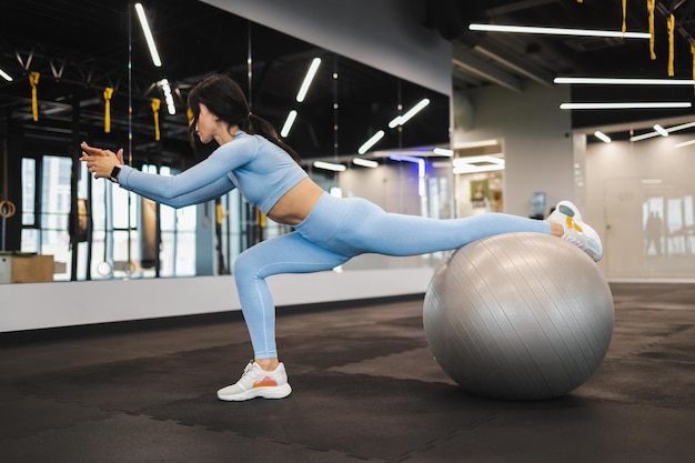 Sports girl doing stretching with fitness ball