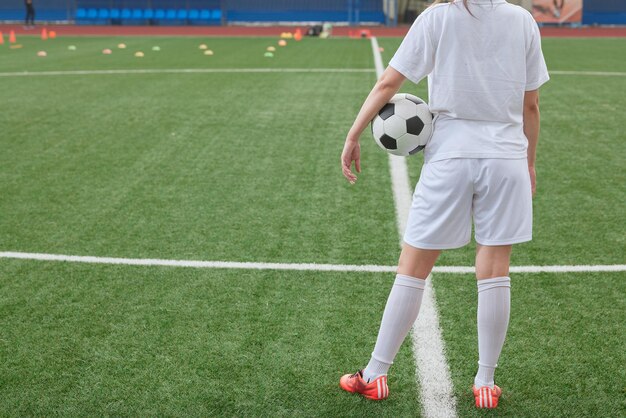 sports girl football player with a soccer ball on the soccer field the concept of professional women's football